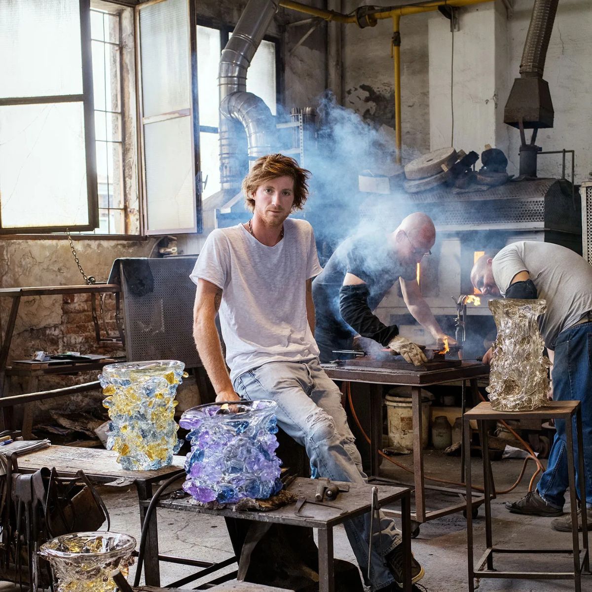 Marcantonio, the new owner of Laguna B, inside the glass blowing studio surrounded by workers.