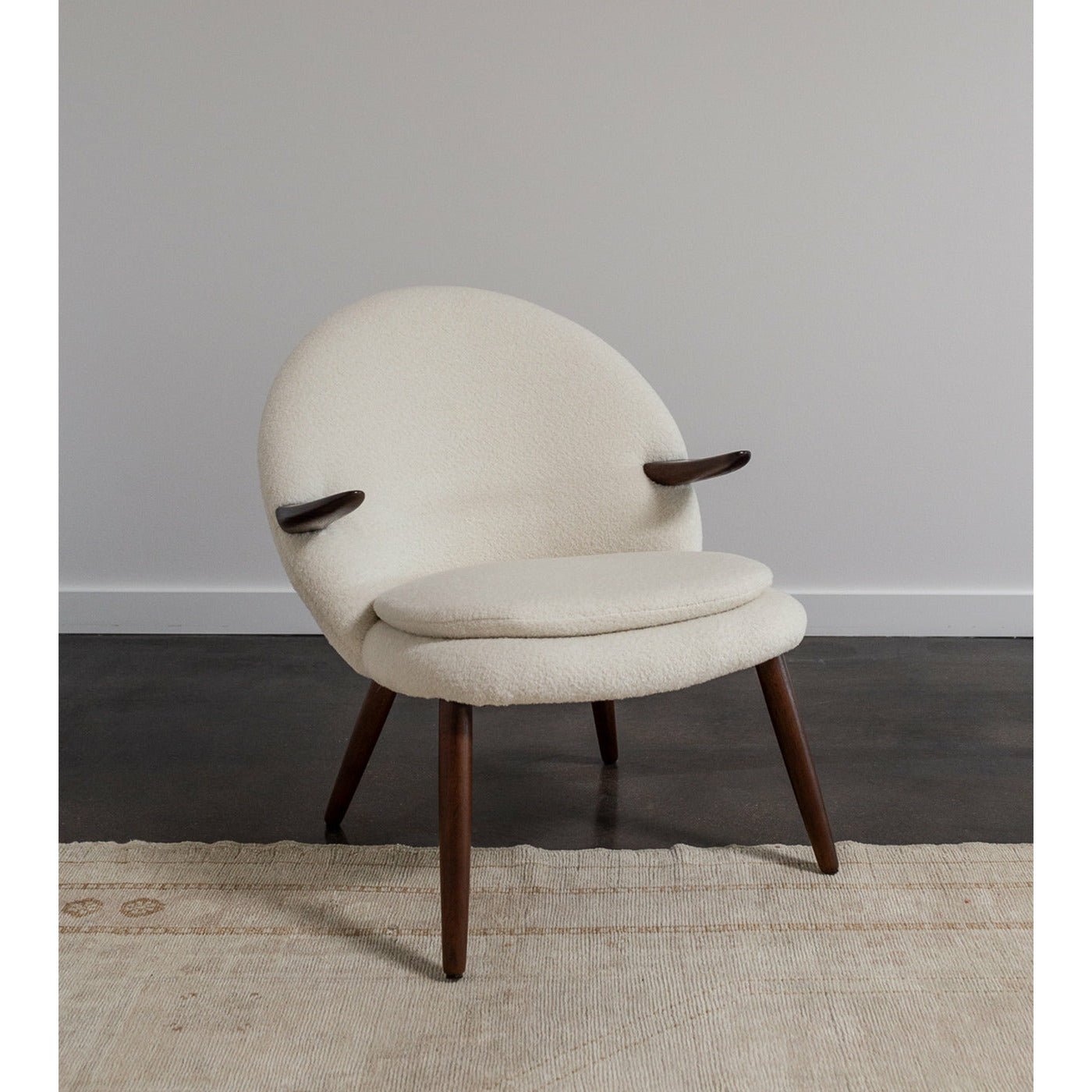Sculptural floating armrests and tapered walnut legs on beautifully restored chair.